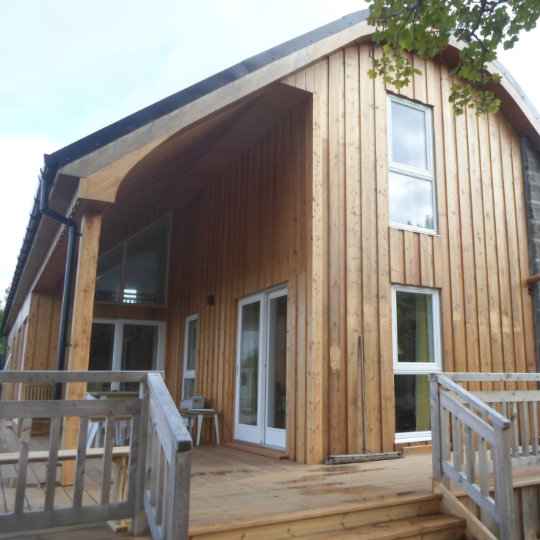 Gable end with feature curved roof and timber and stone cladding