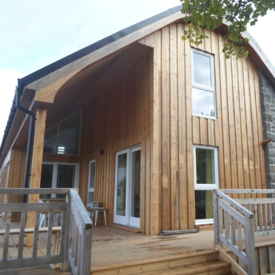 Gable end with feature curved roof and timber and stone cladding